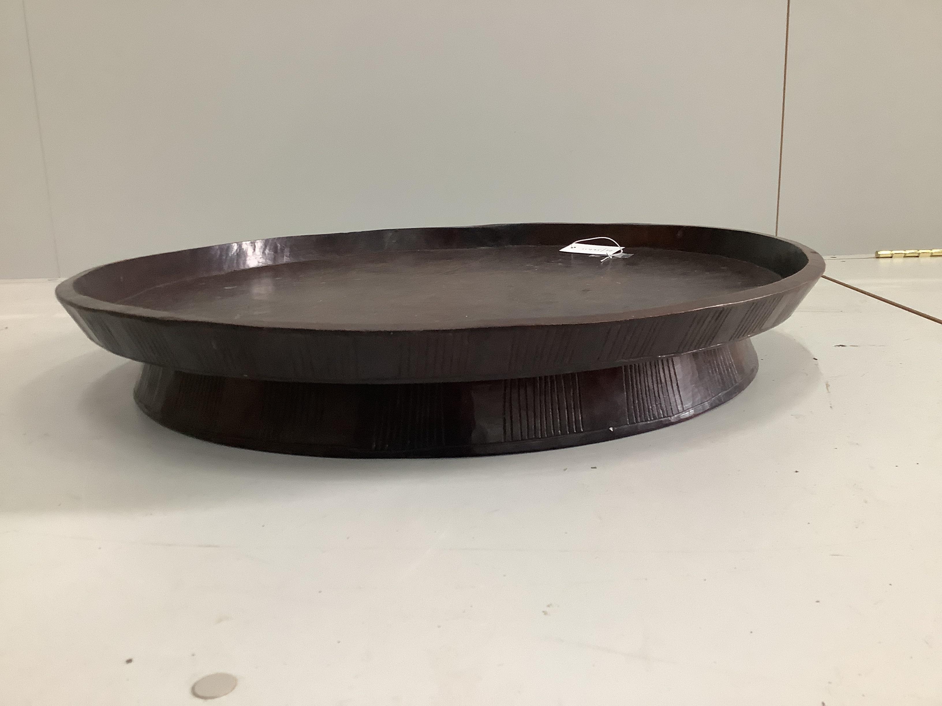 An African circular carved hardwood tray, diameter 66cm, height 10cm